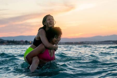 Zwei Personen lachend im Wasser. Der Film "Die Schwimmerinnen". Bildrechte: Laura Radford/ Netflix.